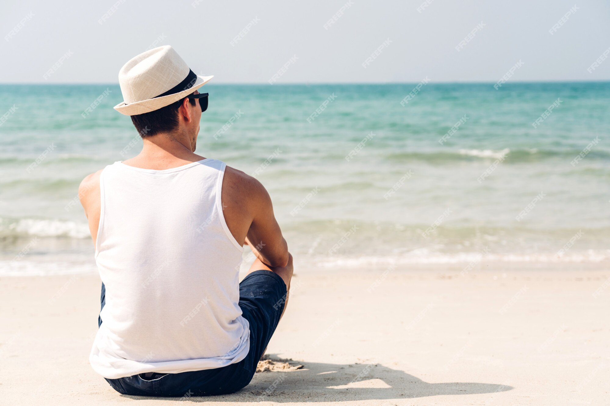 Premium Photo Handsome Man With Sunglasses And Beach Hat Relaxing On