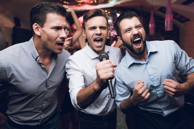 Premium Photo Handsome Men Singing Karaoke In Club