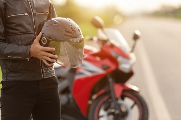 Premium Photo | Handsome motorcyclist wear leather jacket, holding ...