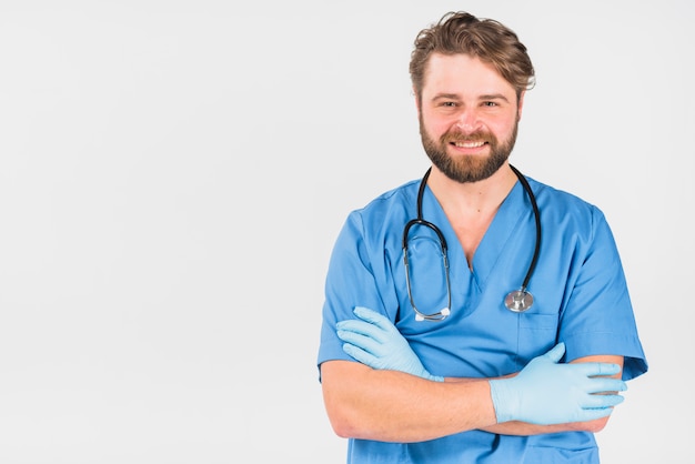 Handsome nurse male smiling and crossing hands Free Photo