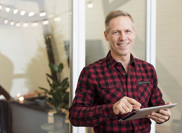 Handsome senior man holding a tablet Free Photo