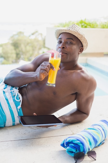 Premium Photo Handsome Shirtless Man Using Tablet Pc Poolside Drinking Cocktail