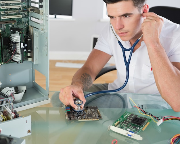 Premium Photo Handsome stern computer engineer holding stethoscope