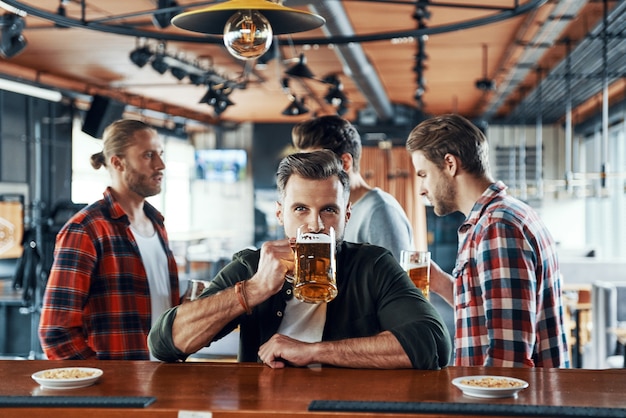 Premium Photo | Handsome young man in casual clothing drinking beer ...