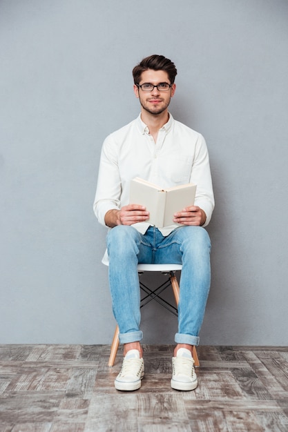 Premium Photo | Handsome young man in glasses sitting on chair and ...