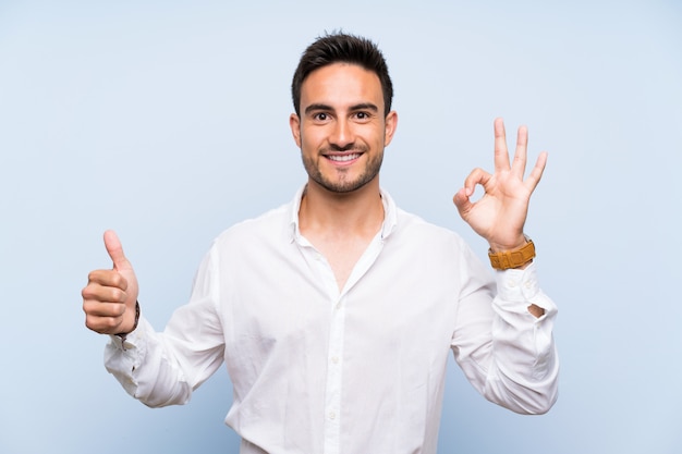 Premium Photo | Handsome young man over isolated blue showing ok sign ...