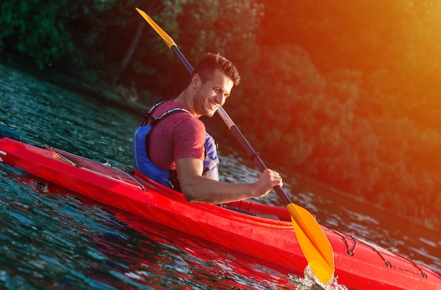 Premium Photo | Handsome young man kayaking on a lake. happy guy ...