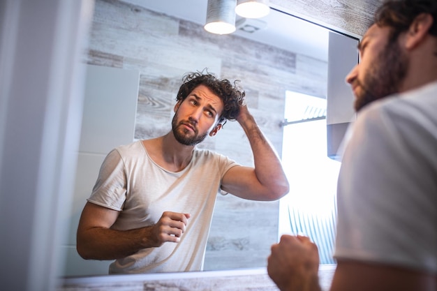 Premium Photo Handsome Young Man Touching His Hair With Hand And Grooming In Bathroom At Home 6272