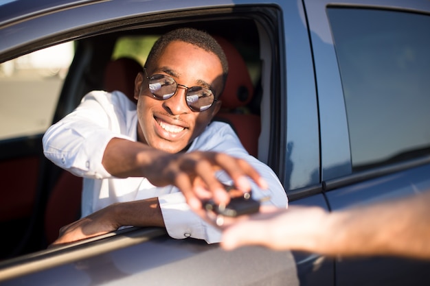 Premium Photo | Happy african american in a car with a key, in the summer