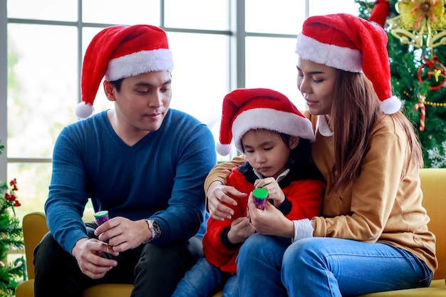 Premium Photo | Happy asian family father mother sitting on sofa ...