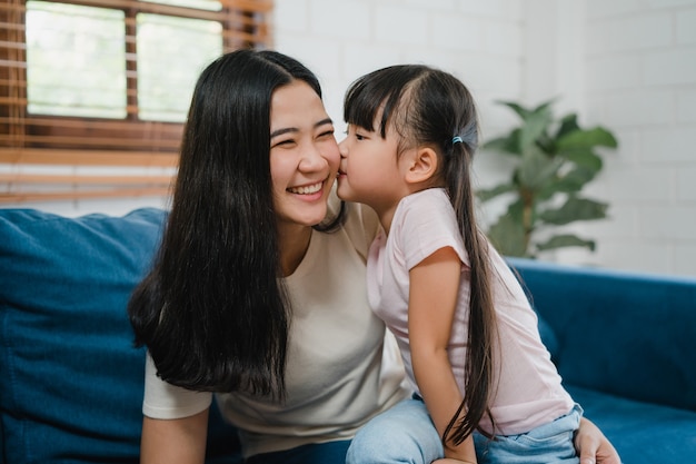 家で誕生日を祝って頬にキスを抱きしめる幸せなアジアの家族のお母さんと娘 無料の写真