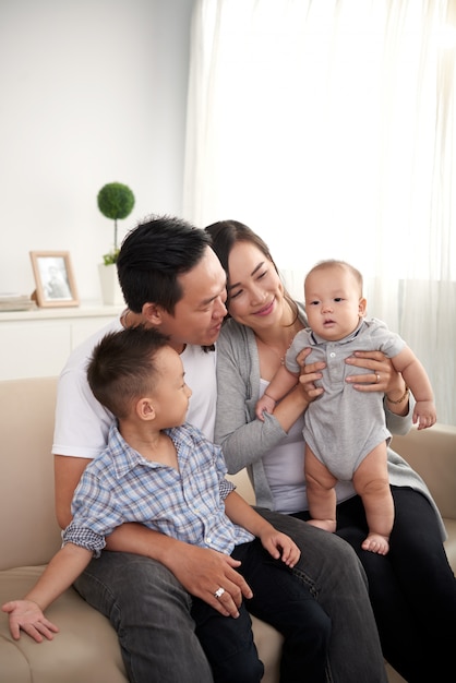 Free Photo Happy asian husband, wife and two kids sitting on couch at ...