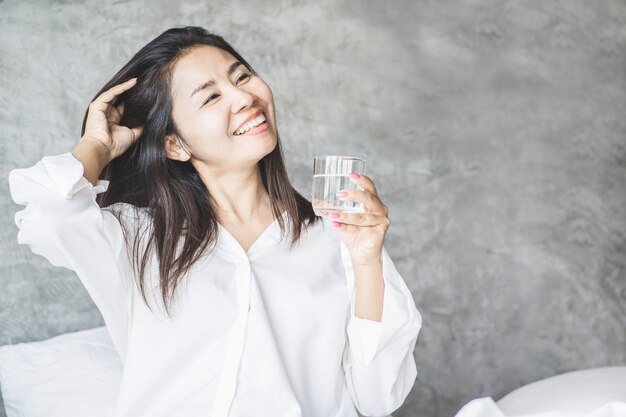 Premium Photo | Happy asian woman drinking fresh water in bed
