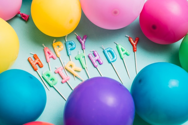 Free Photo | Happy birthday candles stick surrounded with colorful balloons