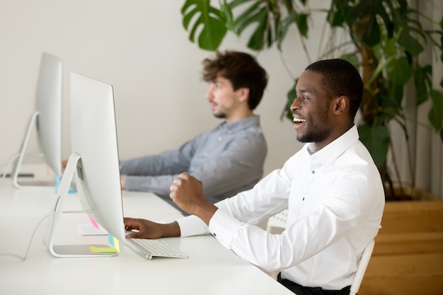 Happy black employee excited by online win or good result Free Photo