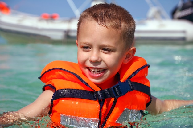 Premium Photo | A happy boy in a life jacket at sea