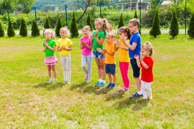 Premium Photo | Happy boys and girls clapping hands standing on the ...