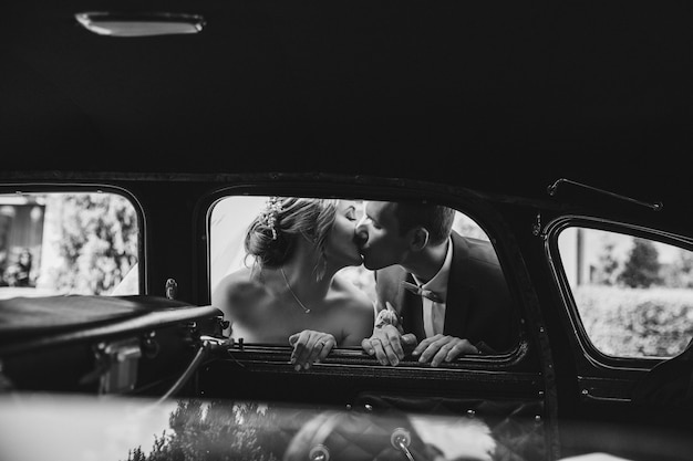幸せな花嫁は車の中でキスしています 無料の写真