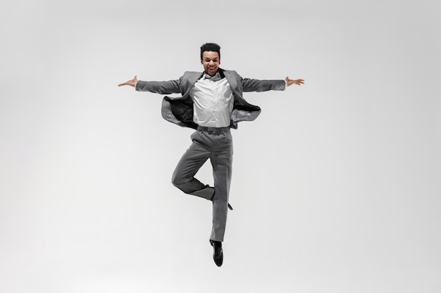 Happy businessman dancing in motion isolated on white studio background. flexibility and grace in business. human emotions concept. office, success, professional, happiness, expression concepts Free Photo