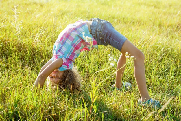 Premium Photo | Happy child doing handstand in summer park