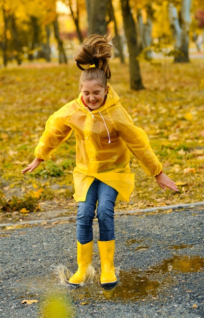 Premium Photo | Happy child girl in yellow raincoat with rubber boots ...