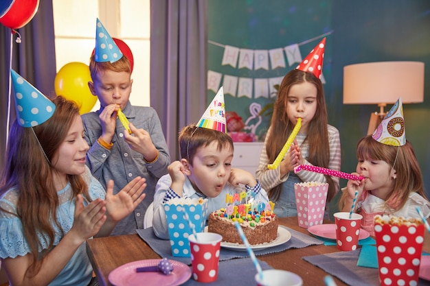 Premium Photo | Happy children in party caps celebrating a birthday
