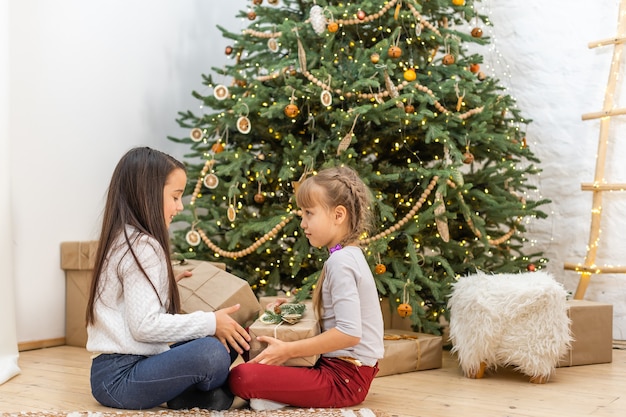 Premium Photo | Happy children with gifts. twins, two little sisters ...