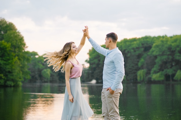 Premium Photo | Happy couple in love guy and girl dancing on the shore of a beautiful lake. gentle and beautiful couple of newlyweds. valentine's day