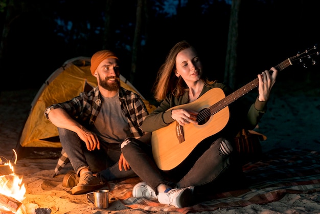 Happy couple singing and playing the guitar Free Photo