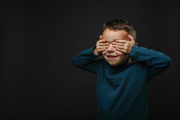 Premium Photo | Happy cute boy is having fun played on black background ...