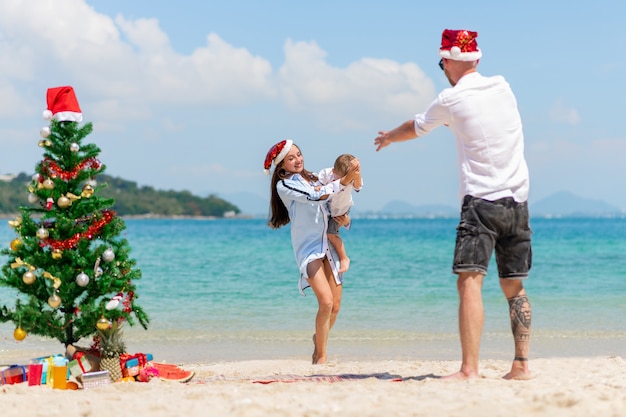 幸せな家族 クリスマスのカップルと子供時代 海の背景 プレミアム写真