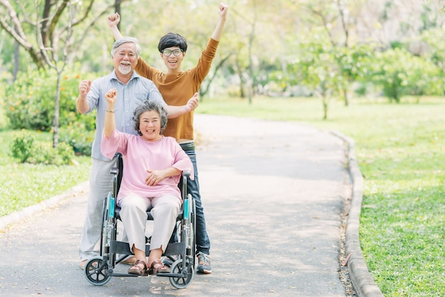 Happy family with senior woman in wheelchair in the park Premium Photo