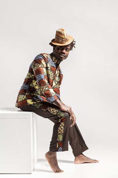 Premium Photo | Happy fashion african man in traditional clothes sit on ...