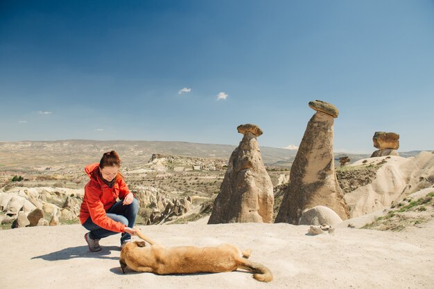 妖精の煙突に地元の犬と結合する幸せな女性旅行者 プレミアム写真