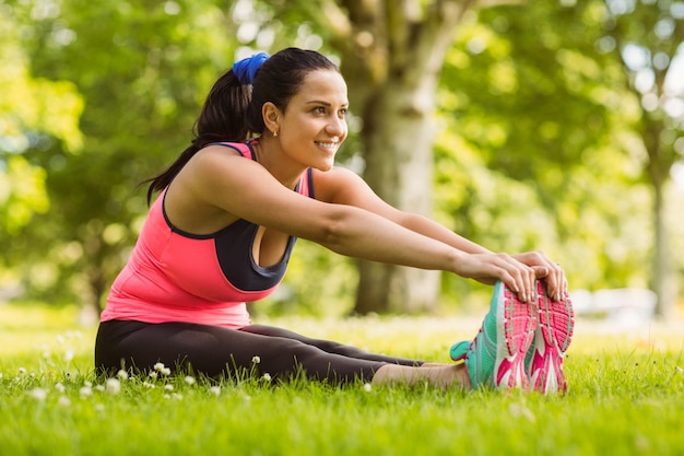 Premium Photo | Happy fit brown hair stretching on the grass