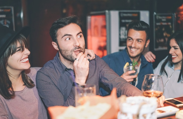 Happy friends having fun drinking cocktail in a bar Premium Photo