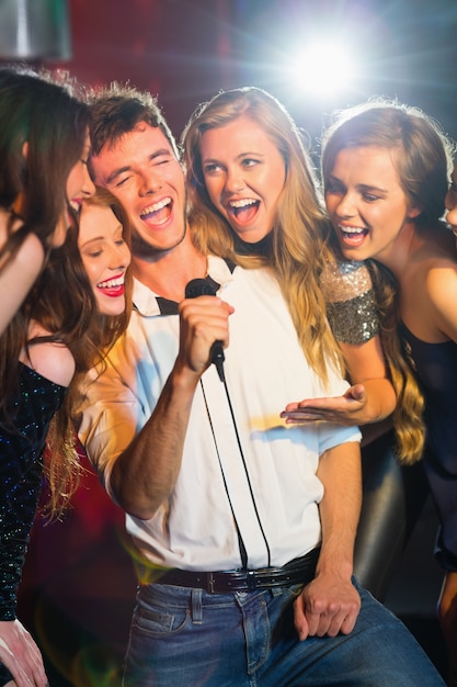 Happy friends singing karaoke together Premium Photo