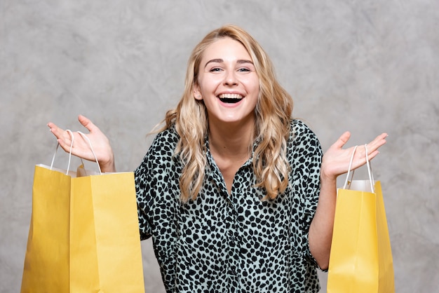 Free Photo | Happy girl holding yellow paper bags