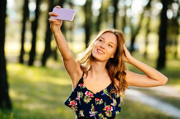 Happy girl makes selfie on a smartphone  Free Photo