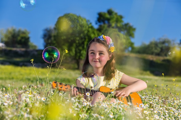 Premium Photo Happy Girl Playing Ukulele In Summer Field