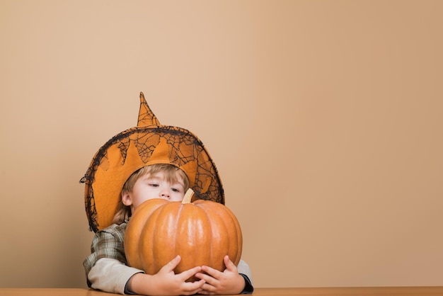 Premium Photo Happy Halloween Cute Boy In Witch Hat Hugging Halloween Pumpkin Jack O Lantern 3550