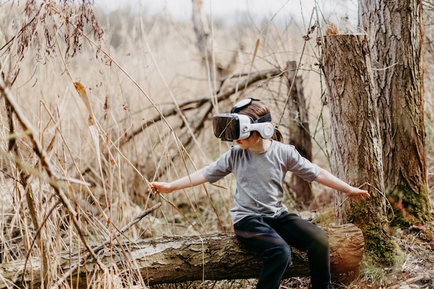 Premium Photo | Happy kid playing and watching reality glasses or vr technology forest nature.