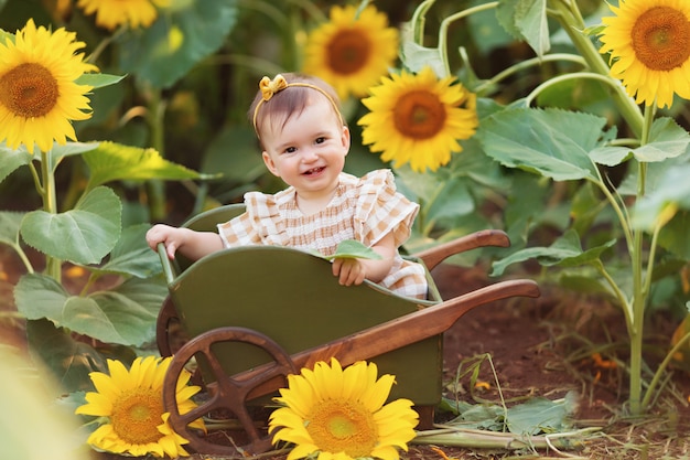 Premium Photo | Happy little girl having fun among blooming sunflowers ...