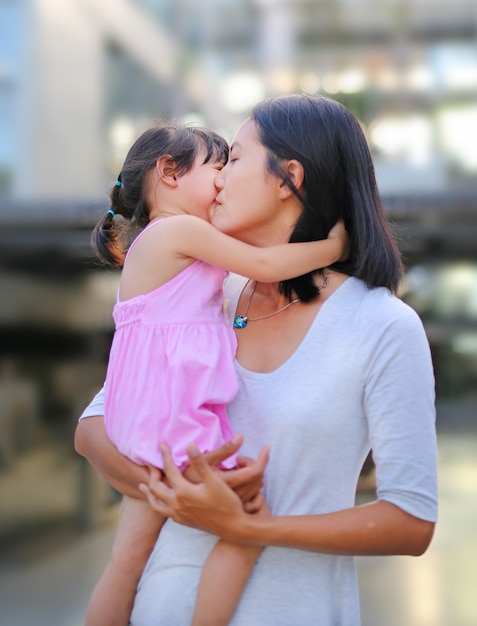 ハッピー愛する家族 母親と子供の女の子は キスとハグ プレミアム写真