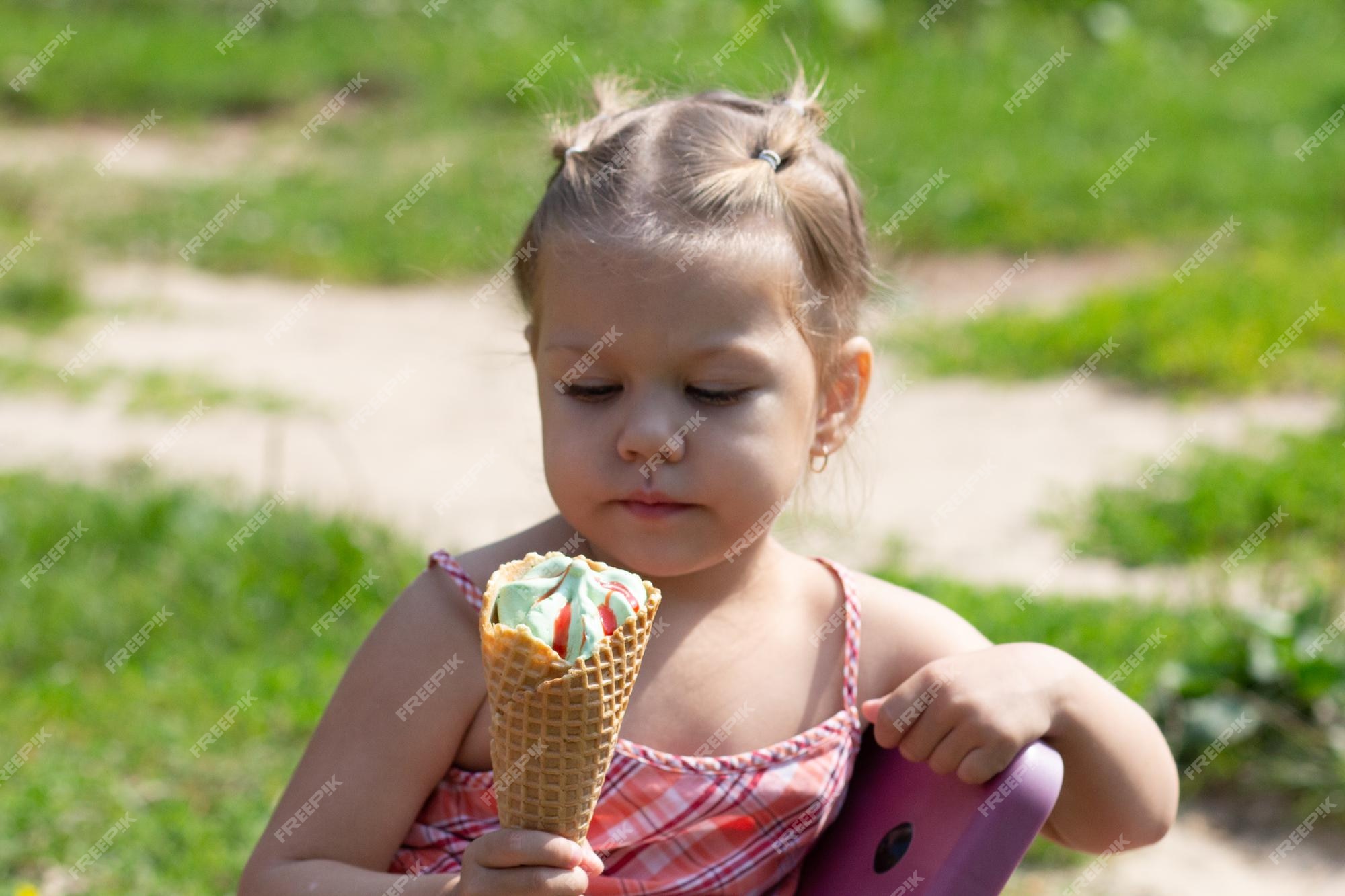 Premium Photo | Happy lttle girl looking at waffle horn of ice cream in ...