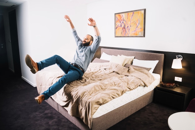 Free Photo | Happy man falling on bed