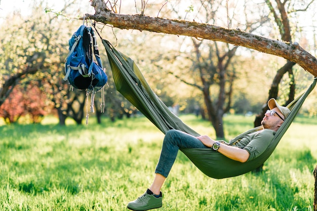 Premium Photo | Happy man relaxing in hammock in sunny park