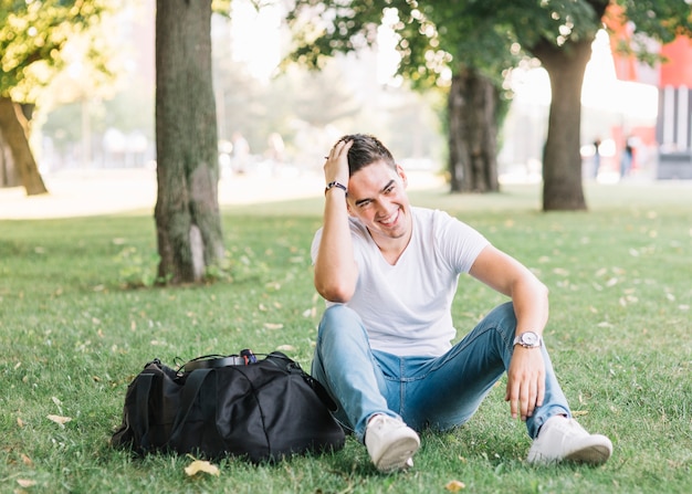 Free Photo | Happy man sitting on grass in park