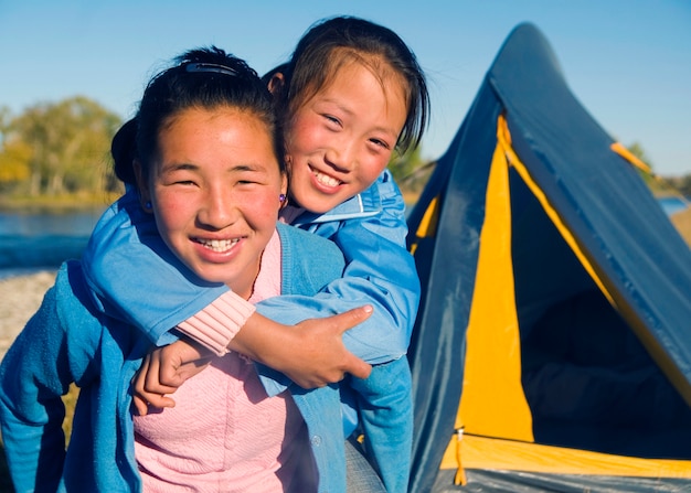 happy-mongolian-girls-playing-piggyback-campsite_53876-23084.jpg