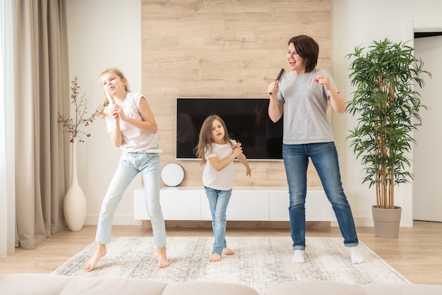 Premium Photo | Happy mother and two daughters having fun singing ...